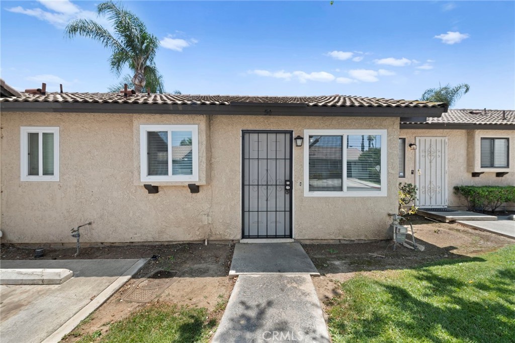 9505 Arlington Avenue, Unit 54 Riverside, CA 92503 - Photo 3 of 29 a front view of a house with a garden