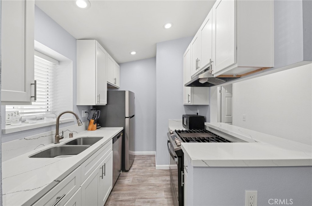 9505 Arlington Avenue, Unit 54 Riverside, CA 92503 - Photo 10 of 29 a kitchen with a sink a stove and cabinets