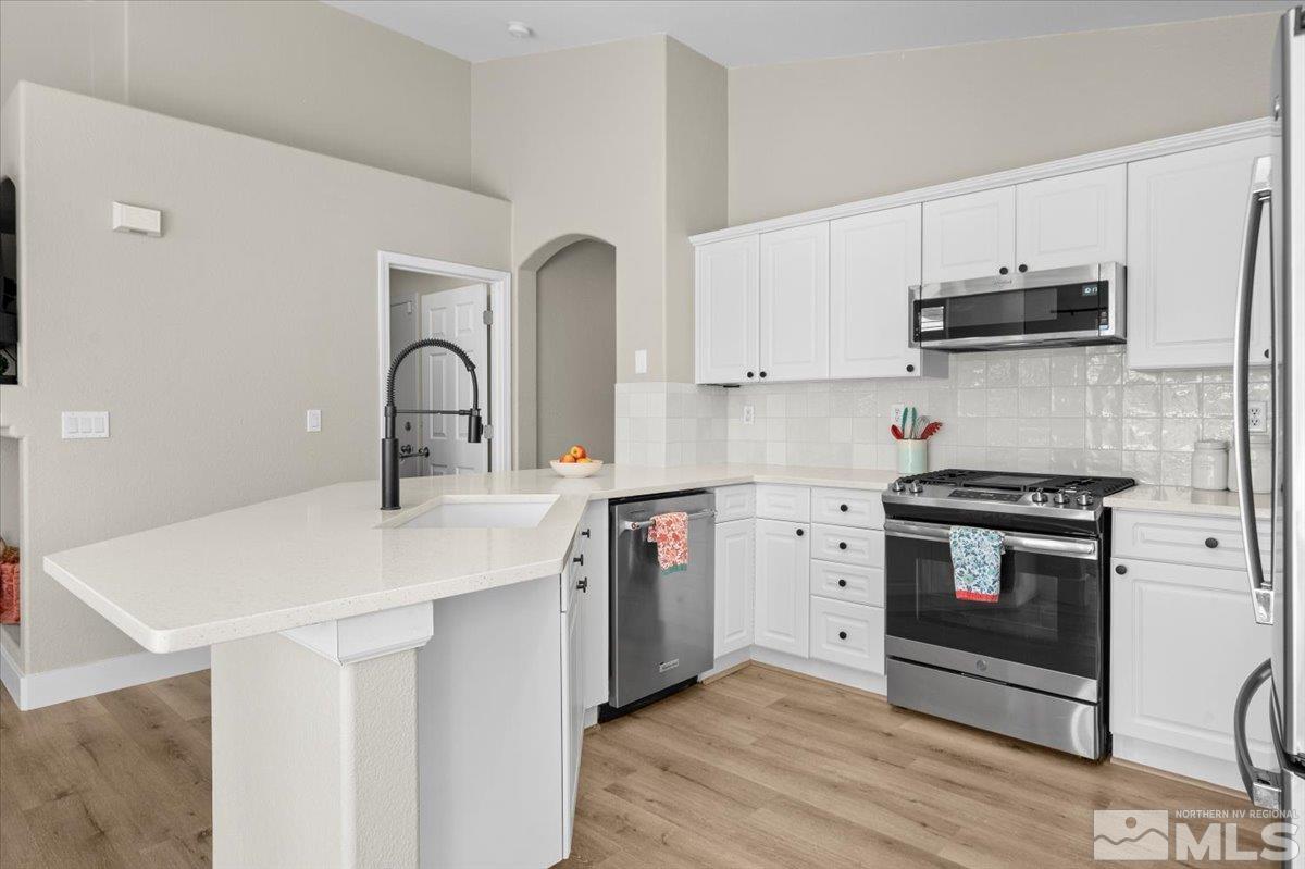 1870 D'Arques Court Reno, NV 89521 - Photo 14 of 33 a kitchen with stainless steel appliances a sink cabinets and wooden floor