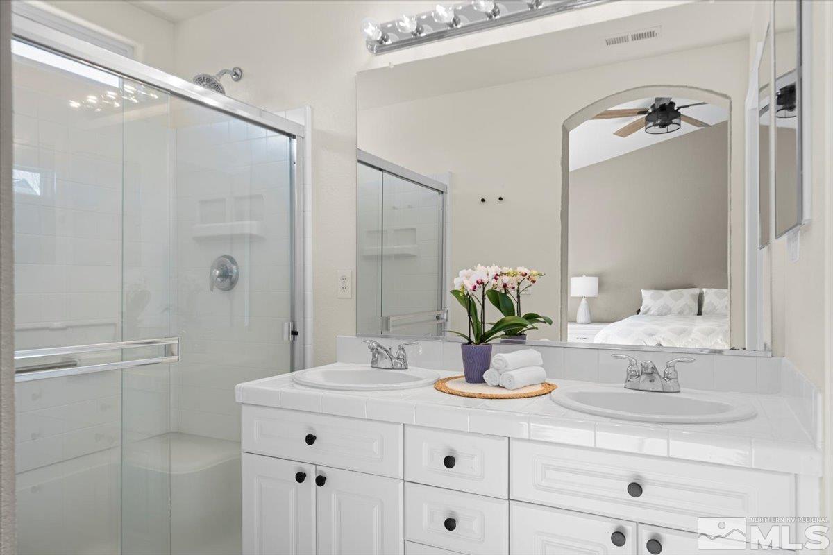 1870 D'Arques Court Reno, NV 89521 - Photo 20 of 33 a bathroom with a granite countertop sink mirror and shower