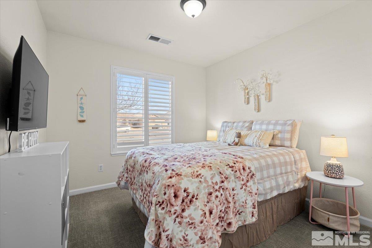 1870 D'Arques Court Reno, NV 89521 - Photo 21 of 33 a bedroom with a large bed and a flat tv screen on dresser