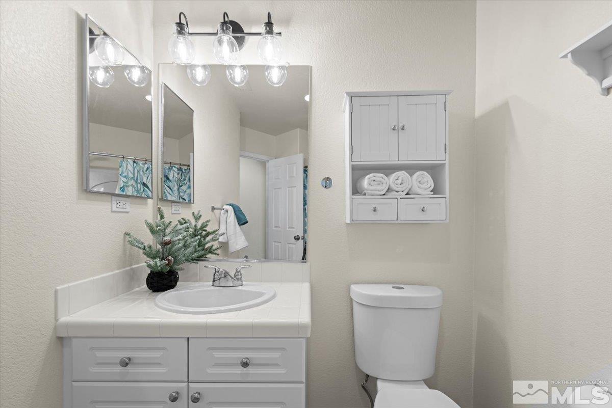 1870 D'Arques Court Reno, NV 89521 - Photo 24 of 33 a bathroom with a sink a toilet and a mirror