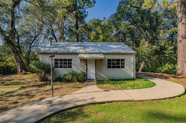 a front view of a house with a yard covered in snow