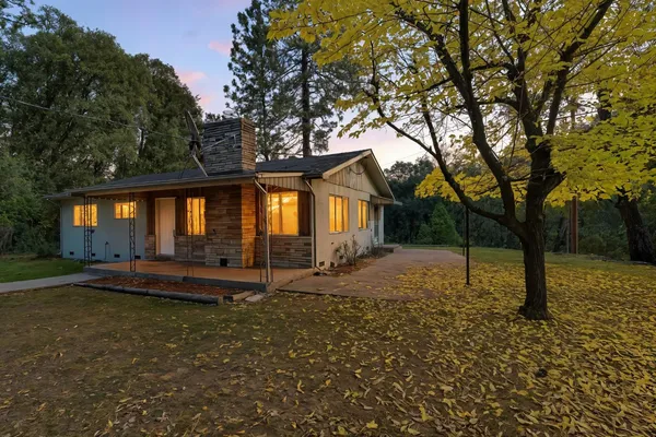 a view of a house with backyard and sitting area