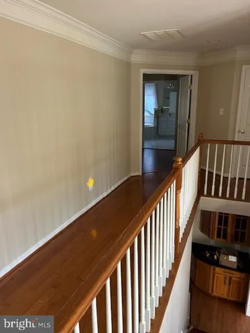 a view of a hallway with wooden floor and staircase