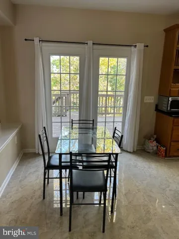 a dining room with furniture and a floor to ceiling window