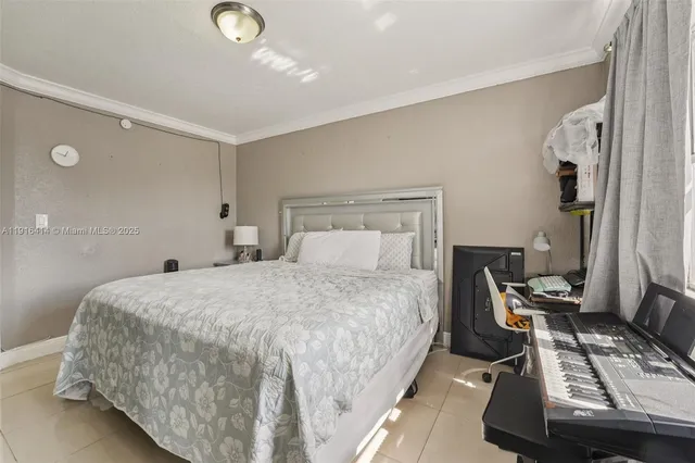 a bedroom with a bed and a flat tv screen on the dresser