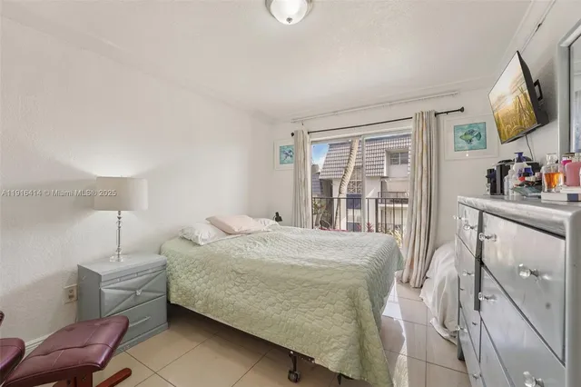 a bedroom with a bed window and flat screen tv