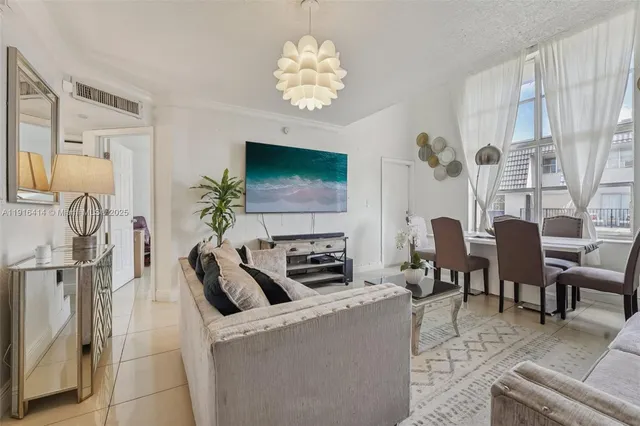 a living room with furniture a fireplace and a chandelier