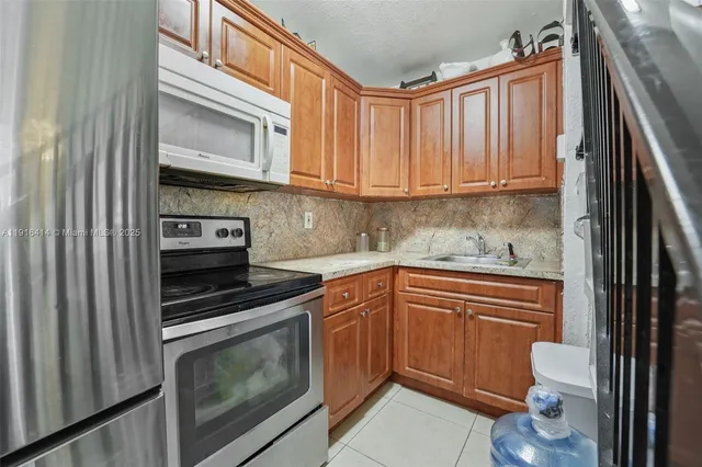 a kitchen with granite countertop a stove sink and cabinets