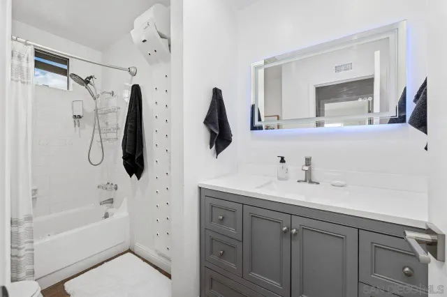 a bathroom with a tub sink and mirror