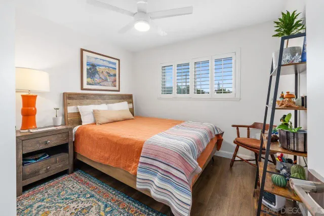 a bedroom with a bed a dresser next to a window