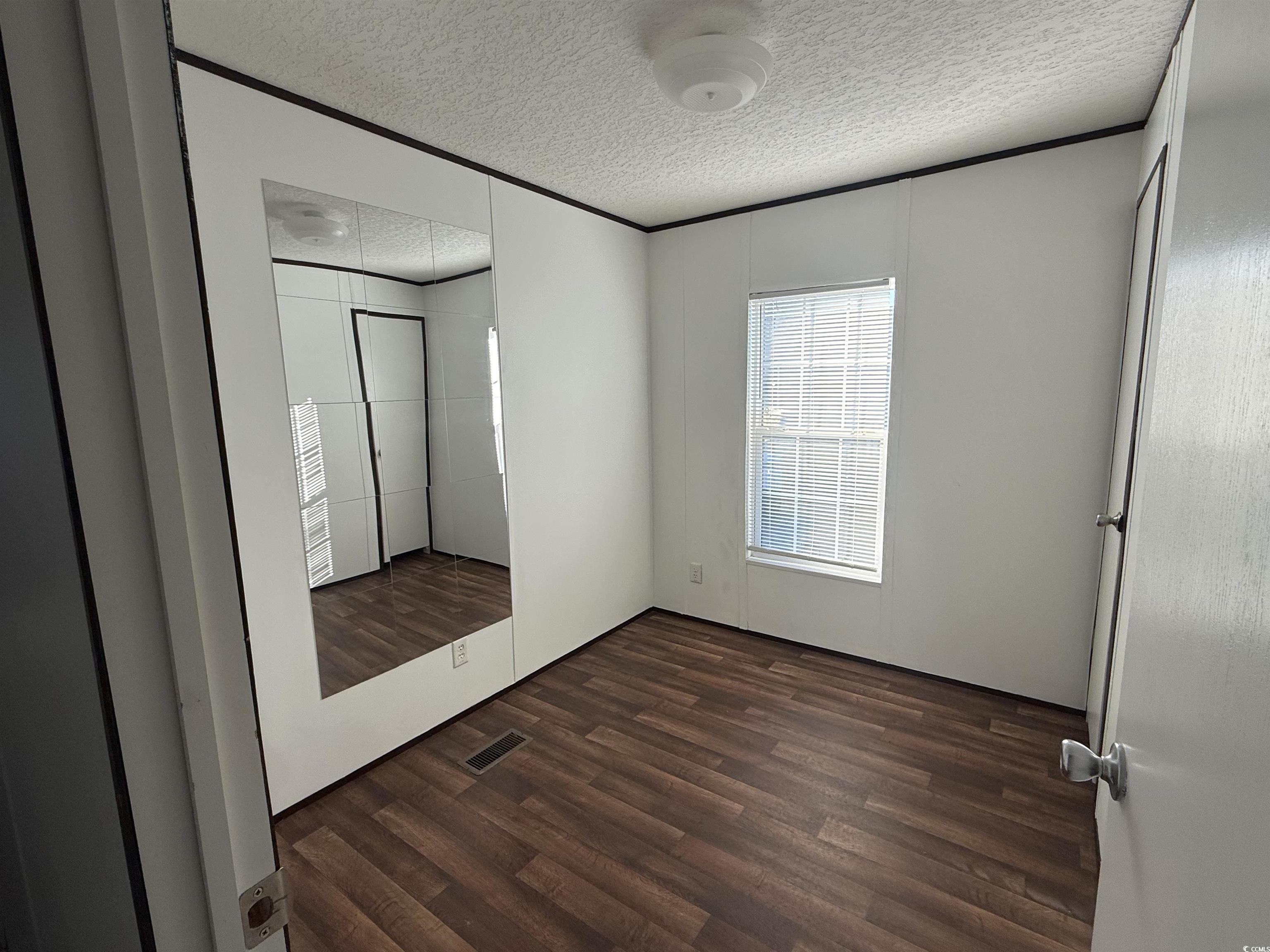 380 Hangar Court Myrtle Beach, SC 29577 - Photo 13 of 16 Full bathroom with vanity, dark wood finished floors, tub / shower combination, a textured wall, and a textured ceiling