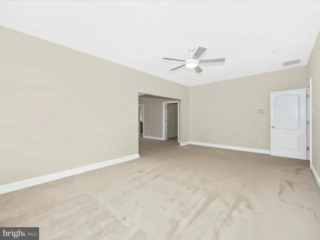 an empty room with a ceiling fan and a window