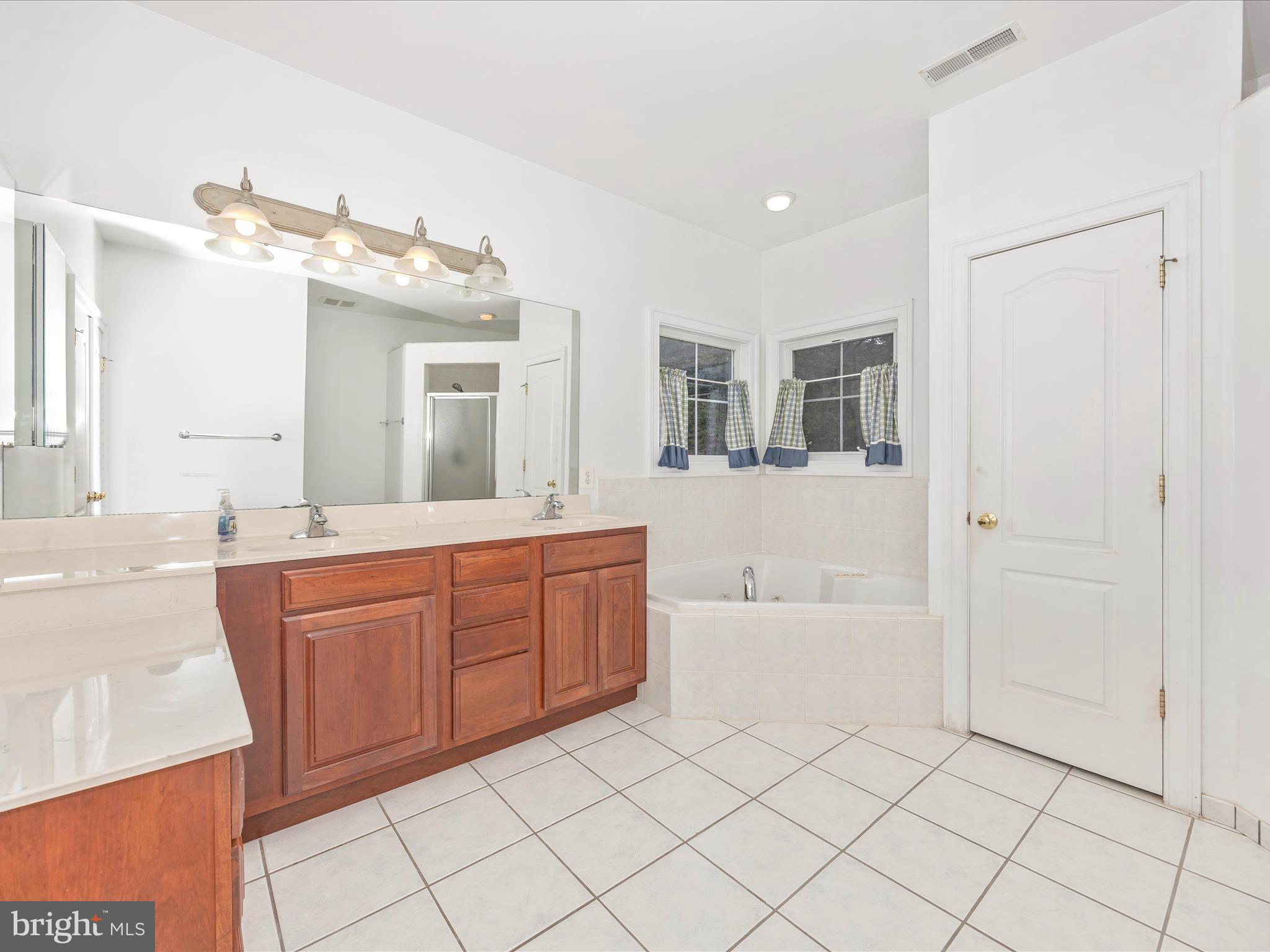 18818 Liberty Mill Road Germantown, MD 20874 - Photo 21 of 39 a spacious bathroom with a granite countertop sink mirror and bathtub