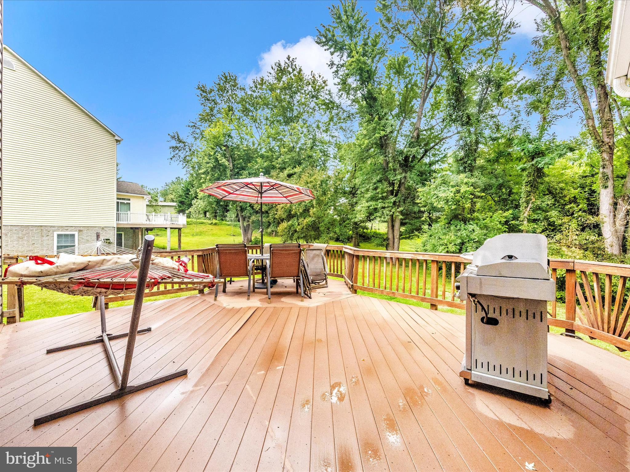18818 Liberty Mill Road Germantown, MD 20874 - Photo 30 of 39 a view of a roof deck with table and chairs under an umbrella with wooden floor