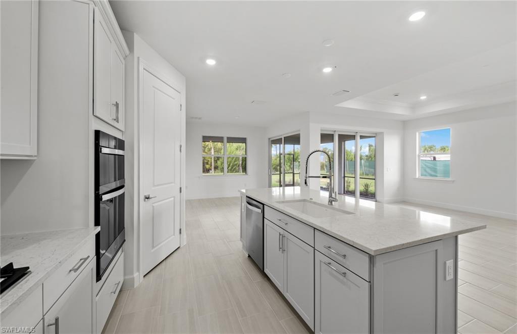 15779 Northridge Road Punta Gorda, FL 33982 - Photo 6 of 24 a kitchen with granite countertop a sink and a stove with refrigerator