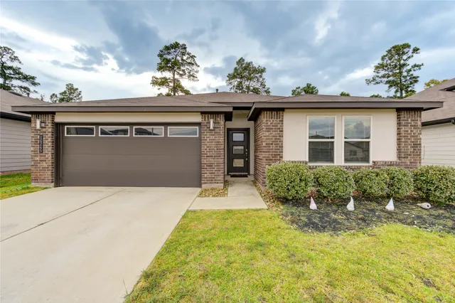 a front view of a house with a yard and potted plants