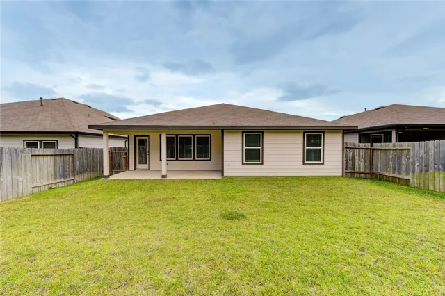 a view of a backyard with a large tree and wooden fence
