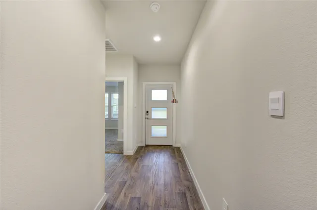 a view of empty room with wooden floor