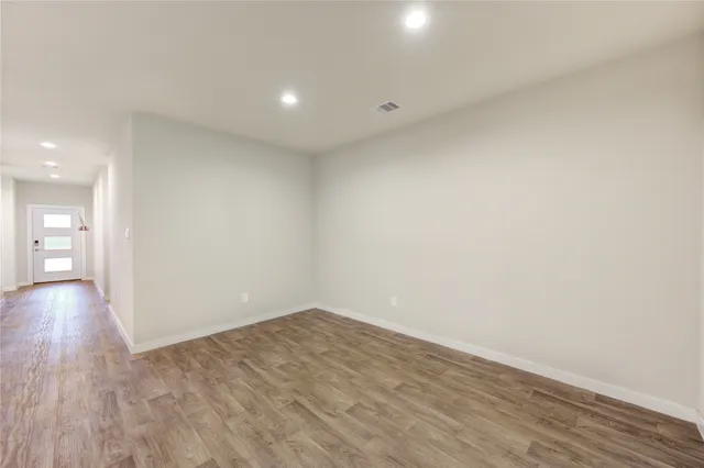 a view of a room with wooden floor and white walls