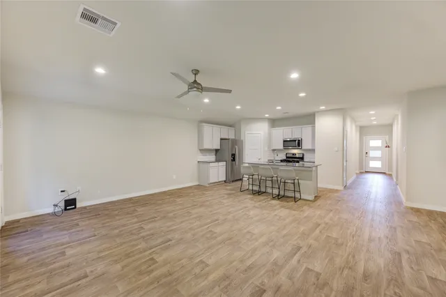 a view of kitchen with kitchen island stainless steel appliances refrigerator stove microwave and cabinets