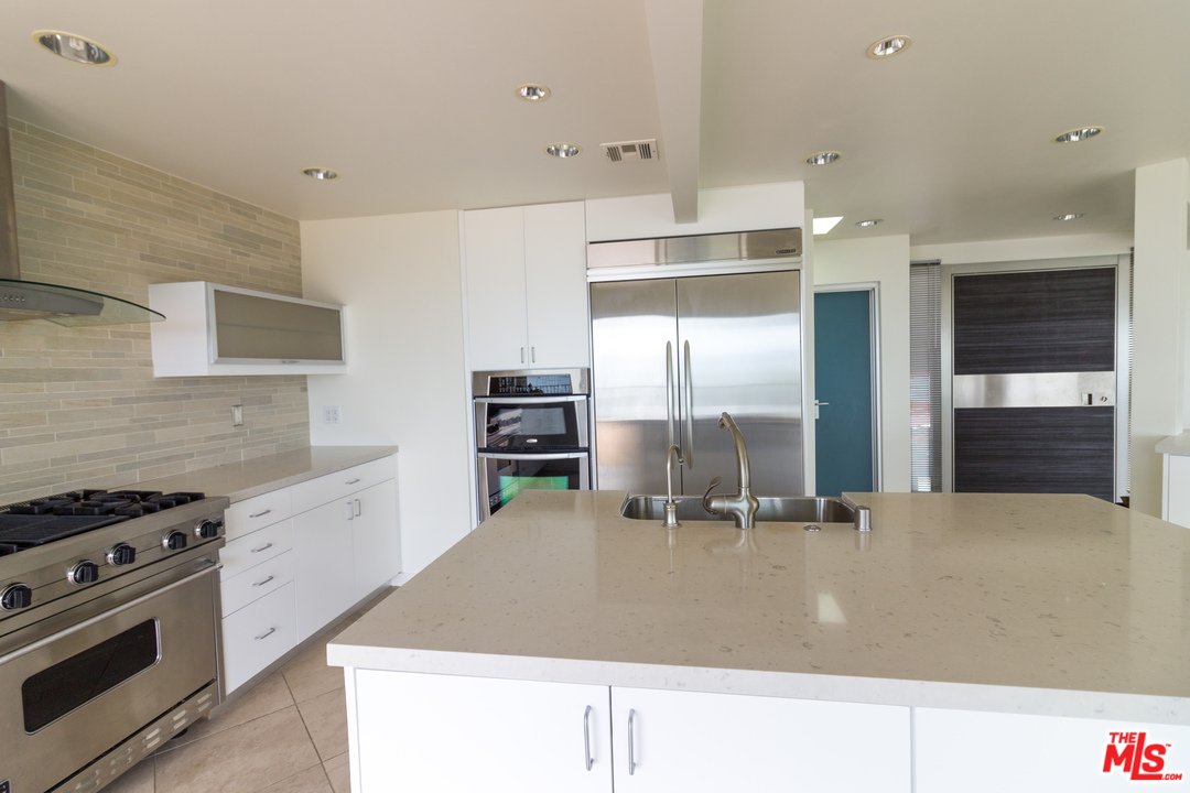 20534 Roca Chica Drive Malibu, CA 90265 - Photo 21 of 38 a kitchen with stainless steel appliances granite countertop a stove a sink and a refrigerator