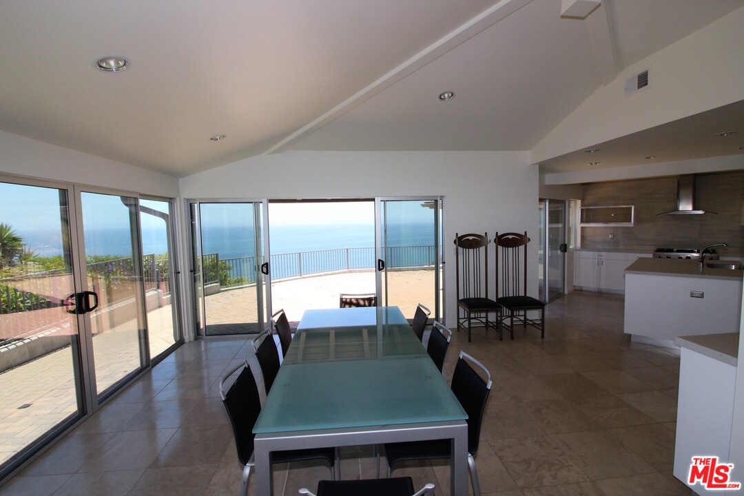 20534 Roca Chica Drive Malibu, CA 90265 - Photo 10 of 38 a dining room with wooden floor and a table