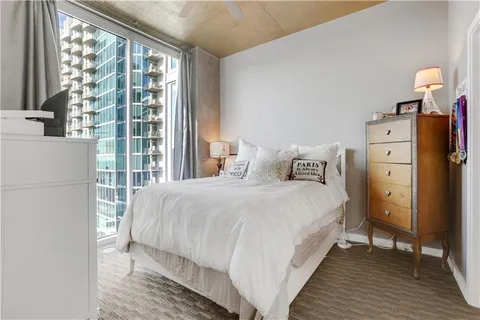 a bedroom with a bed and a refrigerator