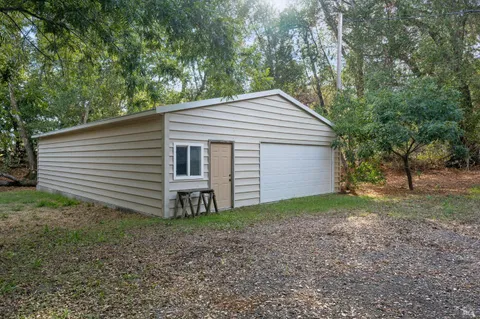 a view of a house with a yard and large tree
