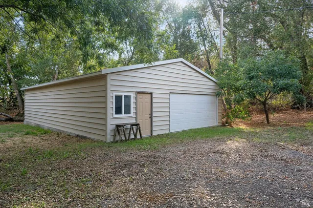 a view of a house with a yard and large tree