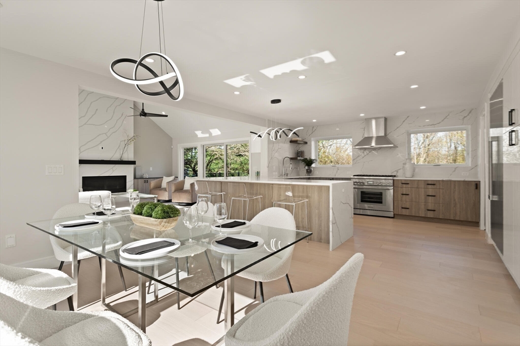 21 Richard Road Lexington, MA 02421 - Photo 14 of 34 a view of a dining room and livingroom with furniture wooden floor a rug a chandelier