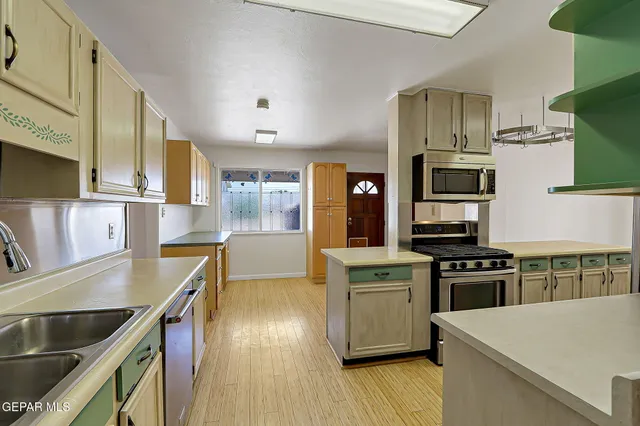 a kitchen with stainless steel appliances granite countertop a refrigerator and cabinets