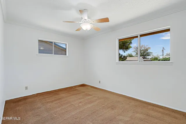 a backyard of a house with table and chairs under an umbrella