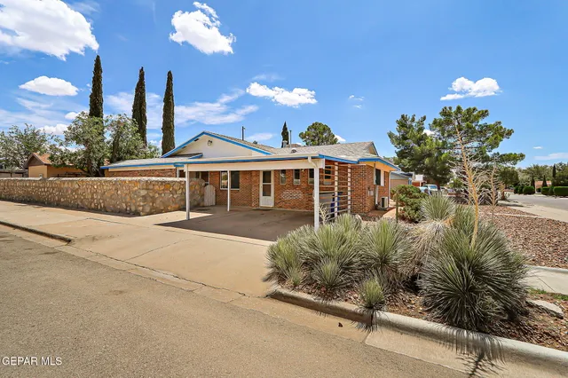 a front view of a house with a yard and garden