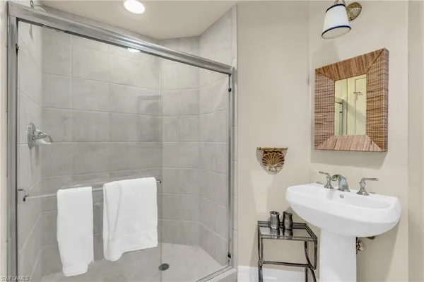 a bathroom with a sink shower and a mirror
