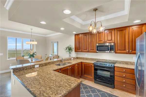 a kitchen with a stove a sink a center island and living room