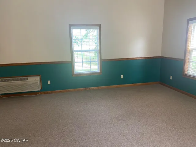 an empty room with windows and closet