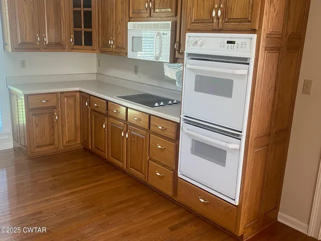 a kitchen with granite countertop white cabinets and white appliances
