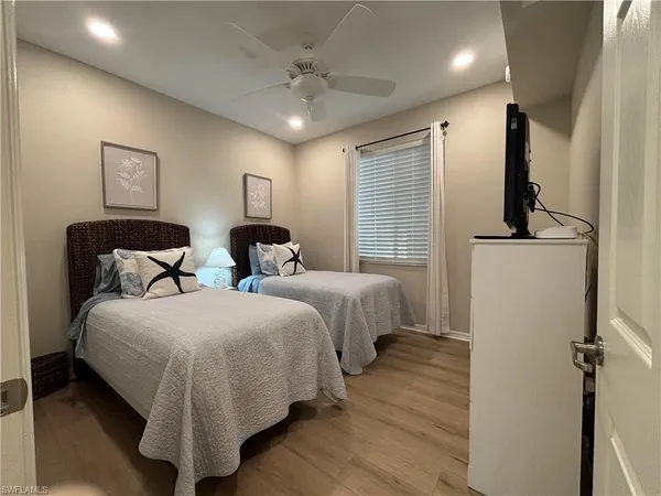 a bedroom with two beds and a chandelier