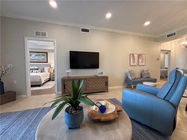 a living room with furniture a flat screen tv and a potted plant