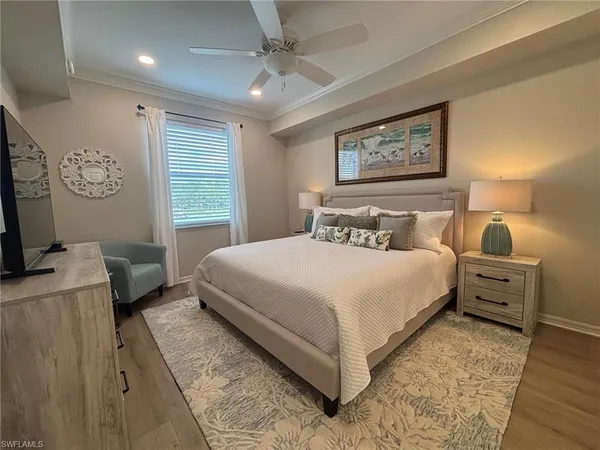 a bedroom with a bed and a flat tv screen on dresser