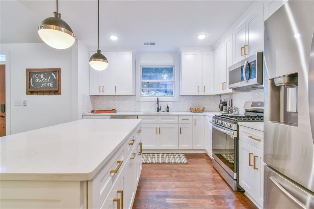1225 Carter Road Decatur, GA 30030 - Photo 11 of 20 a large kitchen with stainless steel appliances granite countertop a stove a sink dishwasher and a refrigerator with wooden floor