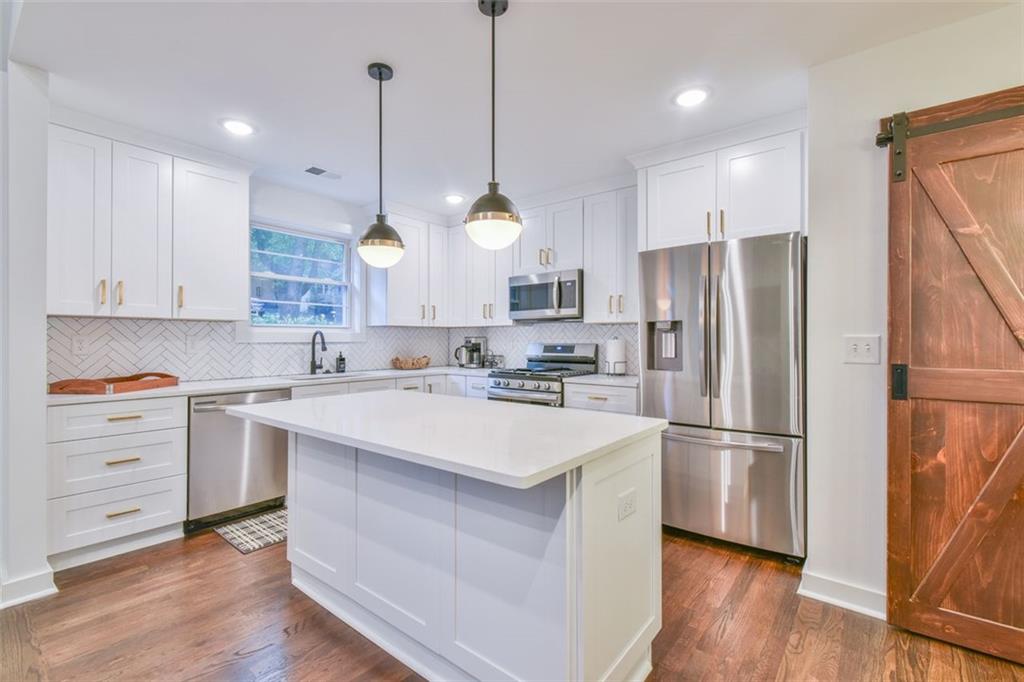 1225 Carter Road Decatur, GA 30030 - Photo 3 of 20 a kitchen with kitchen island white cabinets and stainless steel appliances