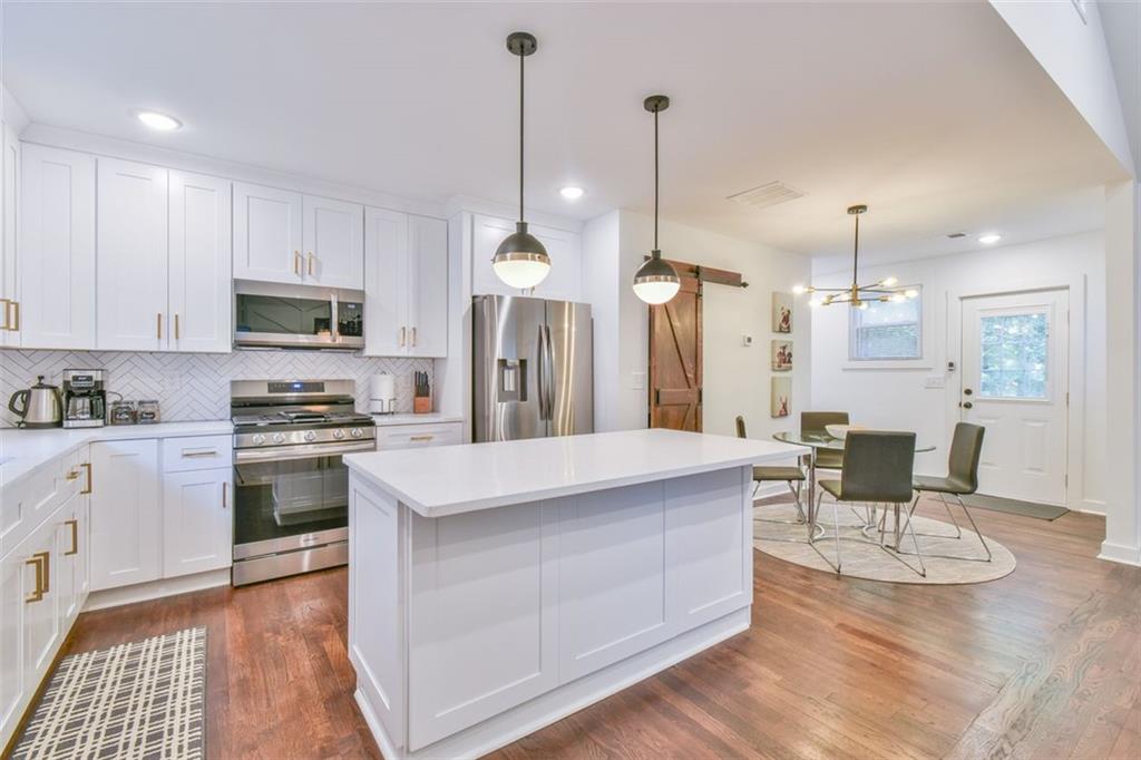 1225 Carter Road Decatur, GA 30030 - Photo 10 of 20 a kitchen with stainless steel appliances kitchen island granite countertop a stove a sink and a refrigerator