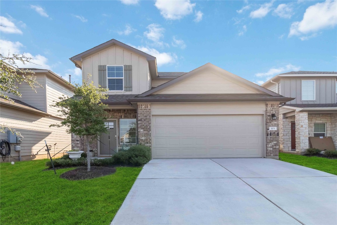 a front view of a house with a yard and garage