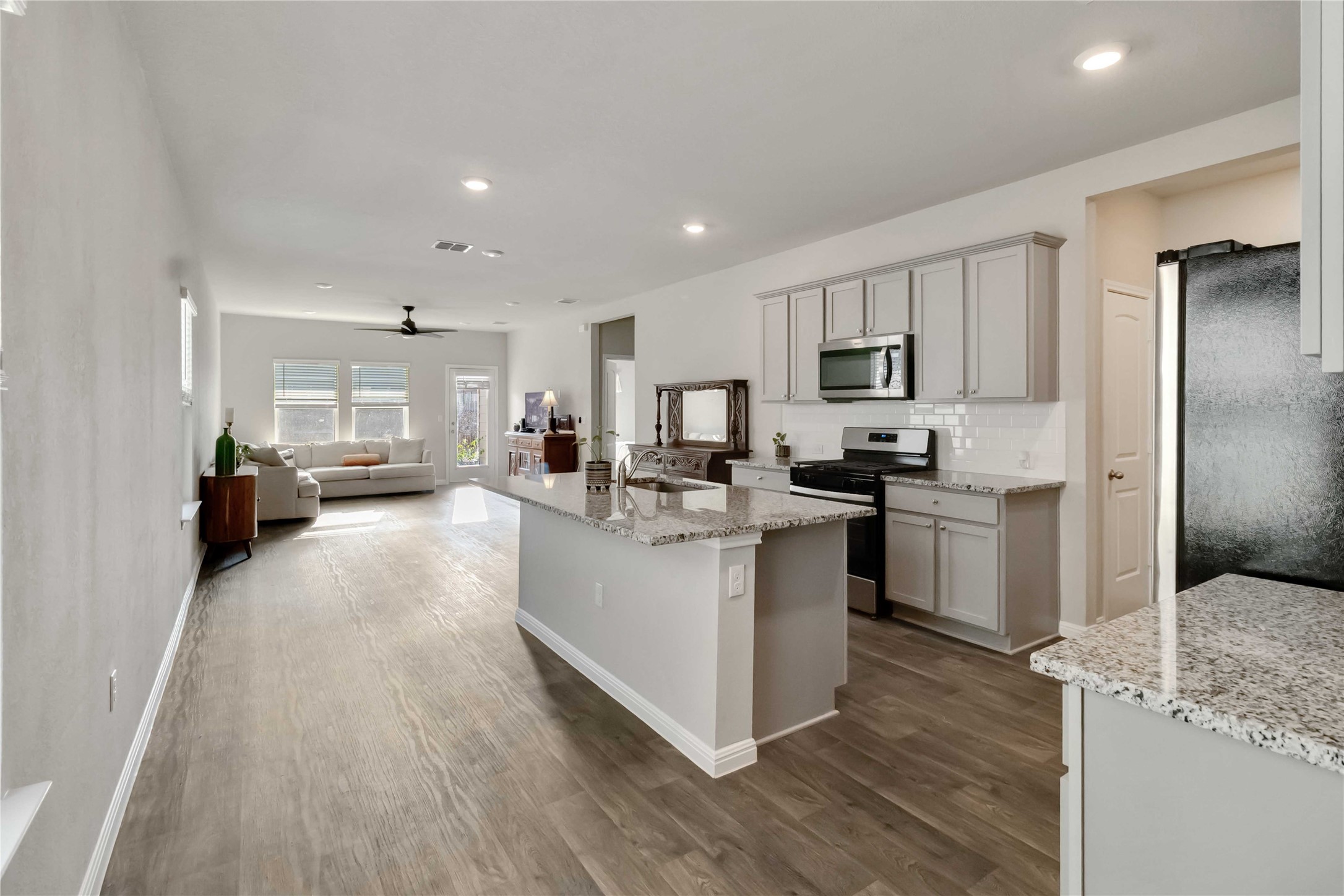103 Mariners Landing Bastrop, TX 78602 - Photo 25 of 25 a kitchen with stainless steel appliances granite countertop a refrigerator a stove top oven a sink dishwasher and white cabinets with wooden floor