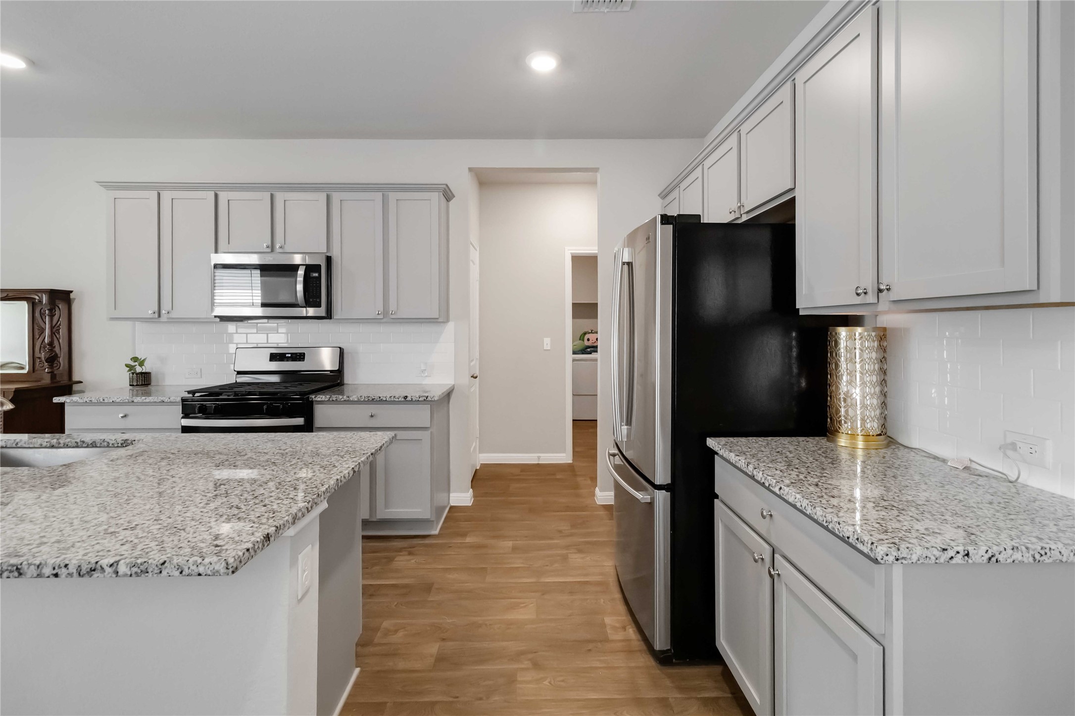 103 Mariners Landing Bastrop, TX 78602 - Photo 4 of 25 a kitchen with granite countertop a refrigerator stove and sink