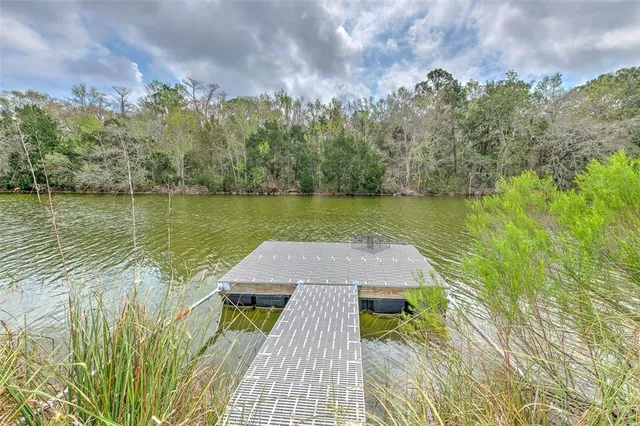 a living room with couches a large mirror and a dining table with wooden floor