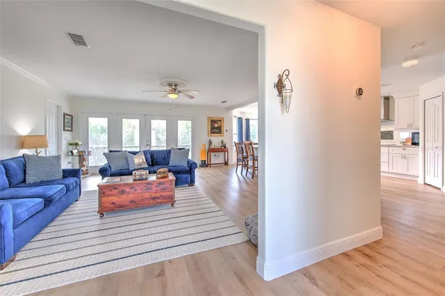 a living room with furniture a chandelier and a dining room